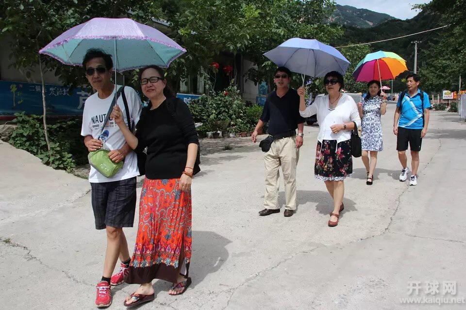 男同志没带伞，女同志主动为他们遮阳。